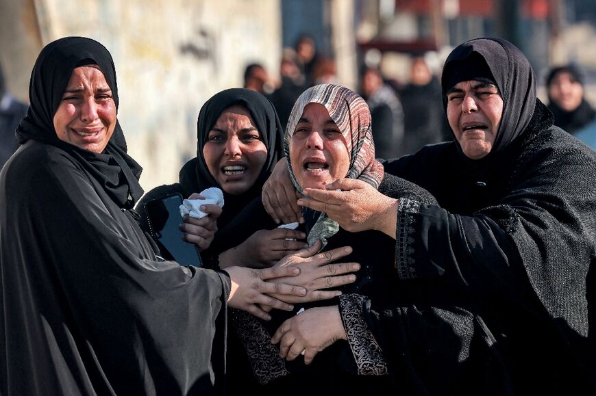 Women in Rafah, the southern Gaza Strip, tend to the sister (C) of Palestinian journalist Adel Zorob, who was killed during Israeli bombardment