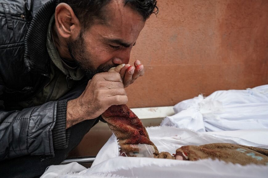 A Palestinian man mourns over the body of a relative killed in Israeli strike at the Nasser hospital in Khan Yunis on the southern Gaza Strip on December 28, 2023