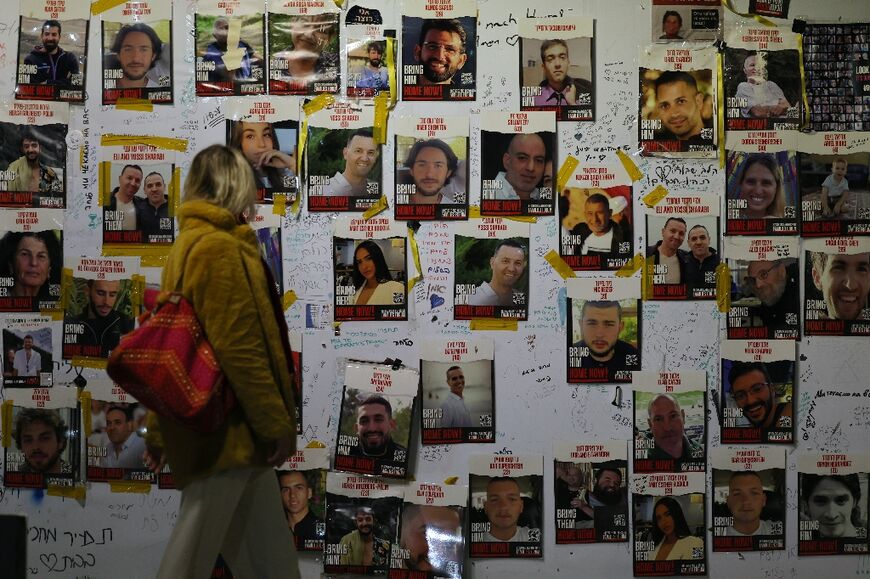 A woman looks at portraits of Israeli hostages on the sidelines of a rally calling for their release, in Tel Aviv