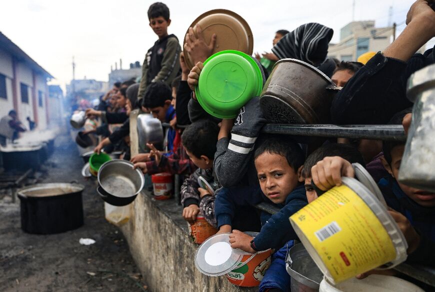 Palestinians children wait to collect food at a donation point in a refugee camp in Rafahs, southern Gaza -- the UN is warning of famine