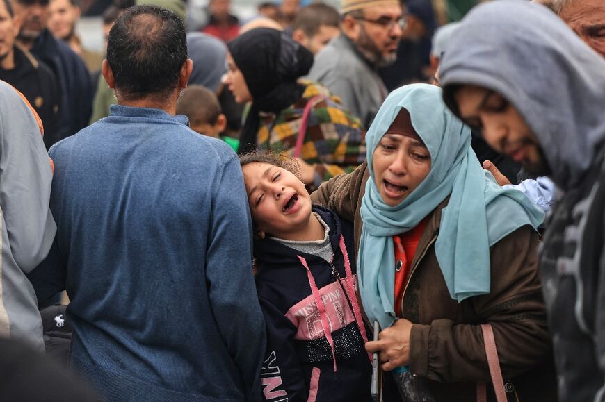 Palestinians outside a hospital in southern Gaza mourn relatives killed in Israeli bombardment 