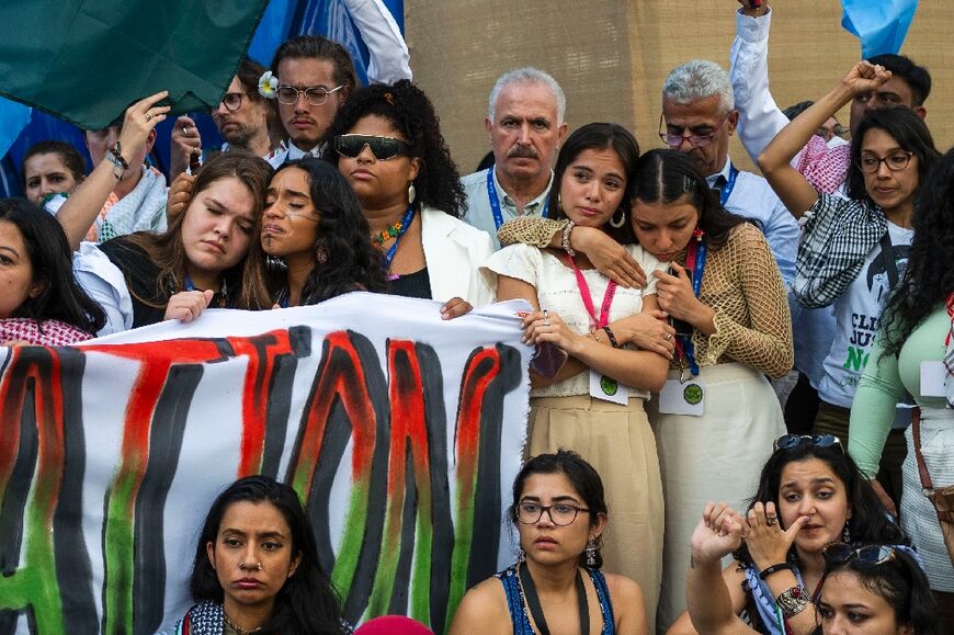 Activists listen to a roll-call of names of Palestinians the Hamas-run health ministry says have been killed in the Gaza war