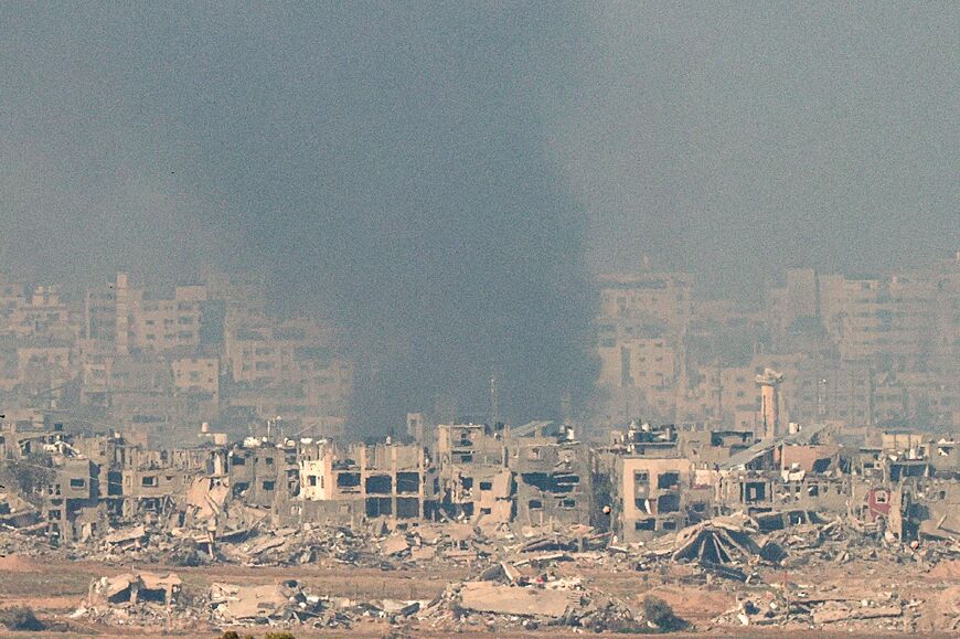 Smoke rises over a heavily damaged area of the Gaza Strip following Israeli bombardment in the third month of a war raging between Israel and Hamas militants in the Palestinian territory