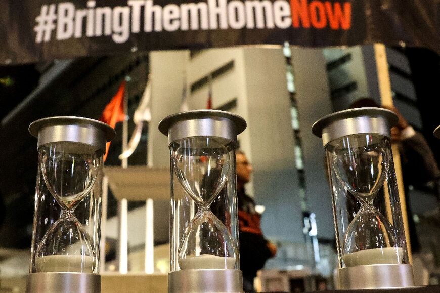 Hourglasses represent hostages still held in Gaza as their families wait for Israeli war cabinet ministers at the entrance to the Defence Ministry in Tel Aviv