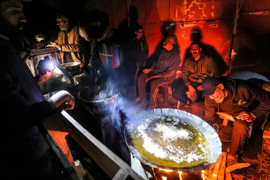 Gazans use flashlights as they cook at night in Rafah