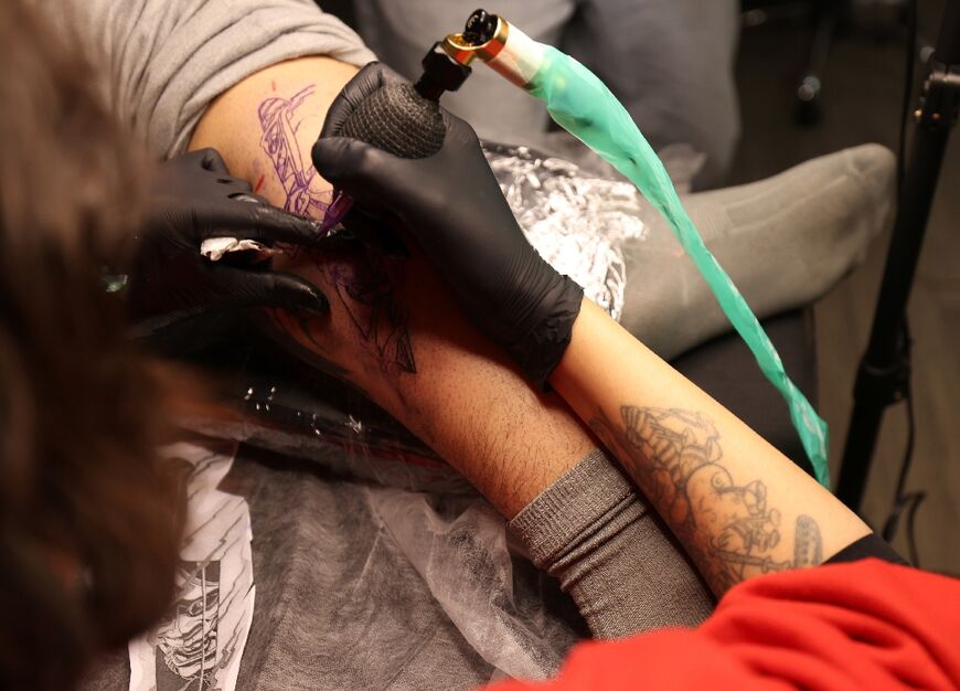 A tattoo artist traces a design on a customer at a tattoo studio in Iran's capital Tehran