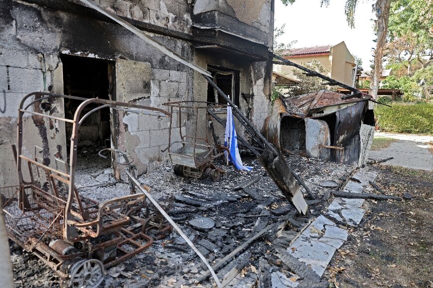 An Israeli flag is seen outside a burnt house in kibbutz Beeri on October 22, 2023