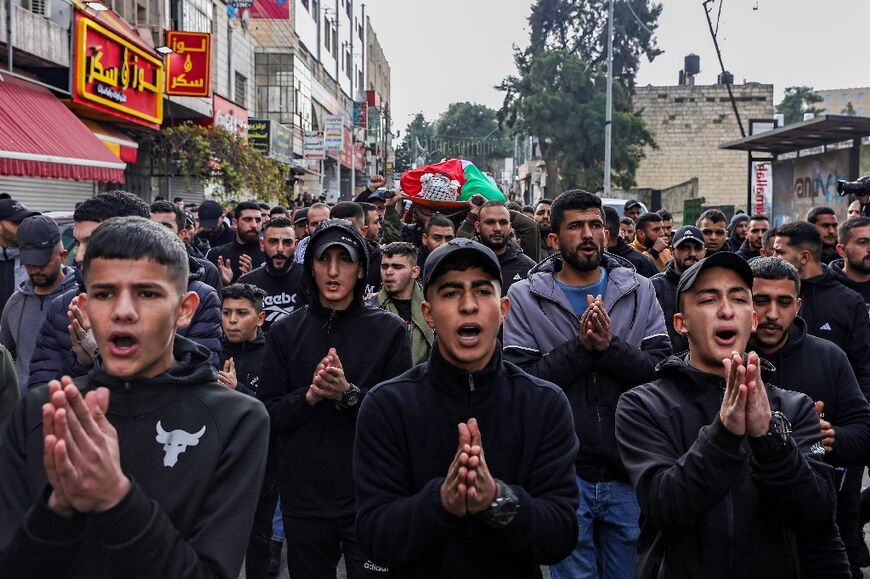 Palestinians carry the body of Hazem Qatawi, killed during an overnight Israeli raid in Ramallah in the occupied West Bank