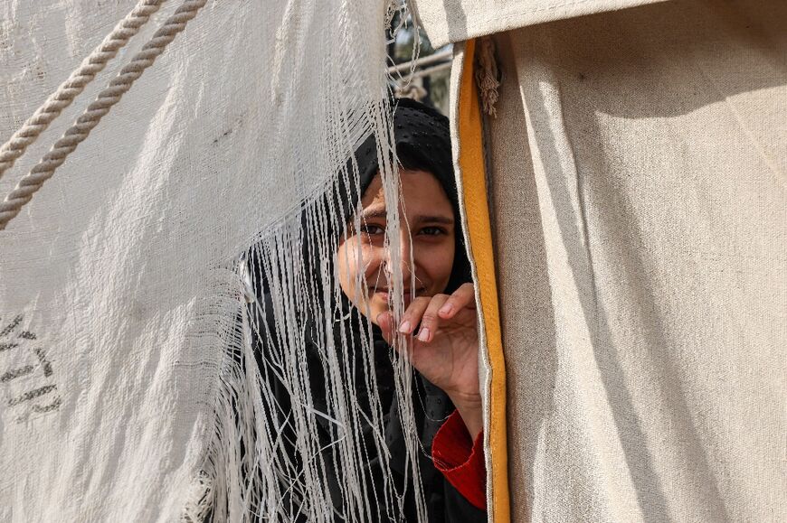 A displaced Palestinian peeps from inside a tent in Rafah, in the southern Gaza Strip