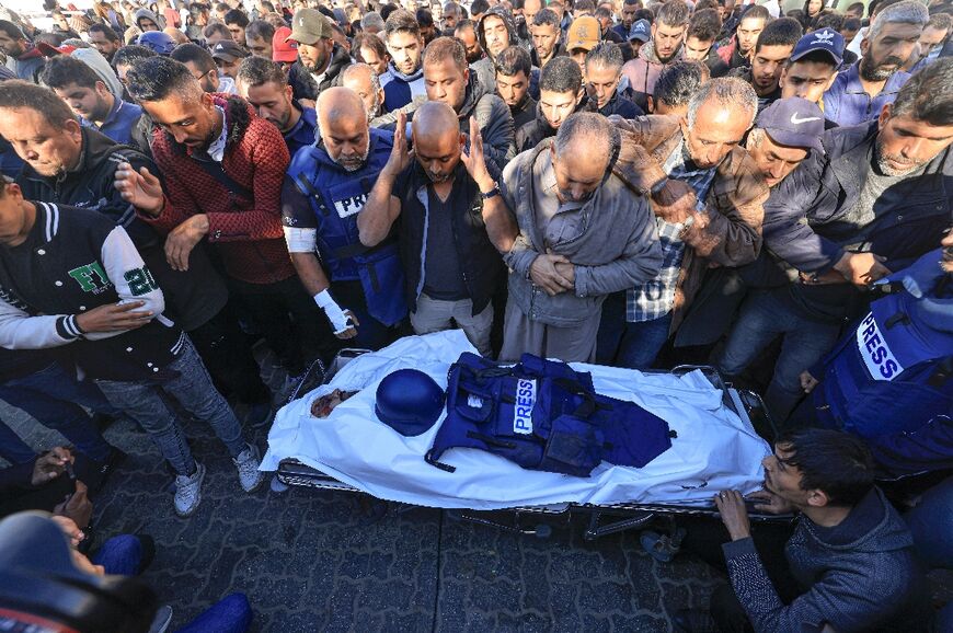 Colleagues and family members pray over the body of Al Jazeera cameraman Samer Abu Daqqa, who was killed during Israeli bombardment