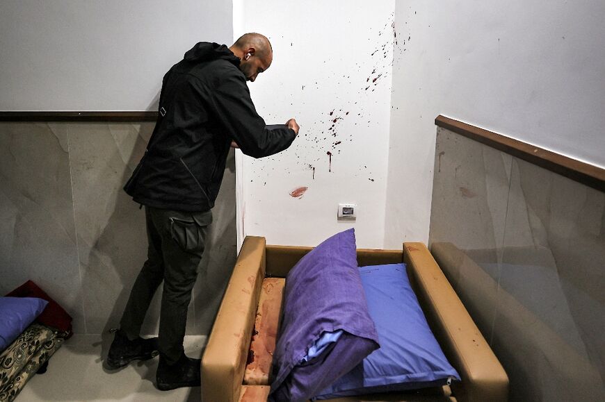 A Palestinian inspects the blood spatter on a wall in another part of the Ibn Sina Hospital after the Israeli raid that the army says targeted Hamas militants