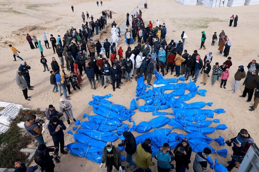 Palestinian health ministry staff prepare to bury dozens of unidentified Gazans in a mass grave after their bodies were exhumed then returned by Israel, according to Gaza officials