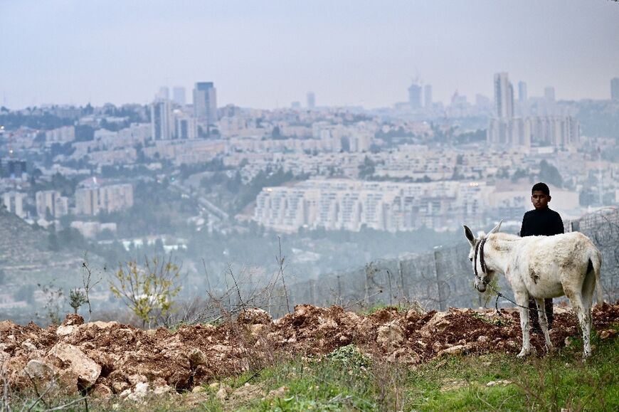 A Palestinian youth in front of the separation barrier in Al-Walaja