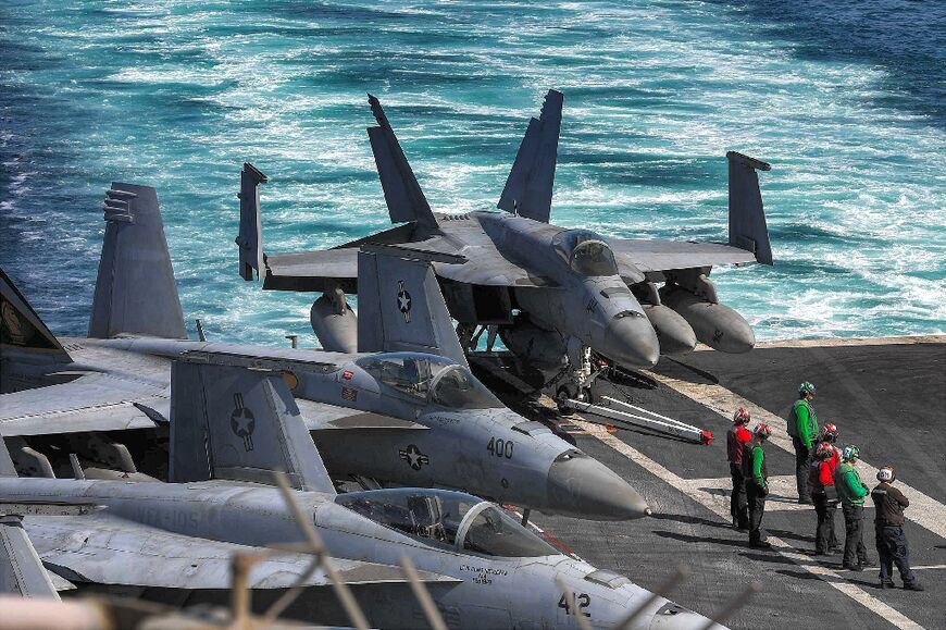 US Navy F/A-18 Hornet aircraft on the deck of the aircraft carrier USS Dwight D. Eisenhower (CVN 69), which is assigned to help protect the vital Red Sea shipping lane