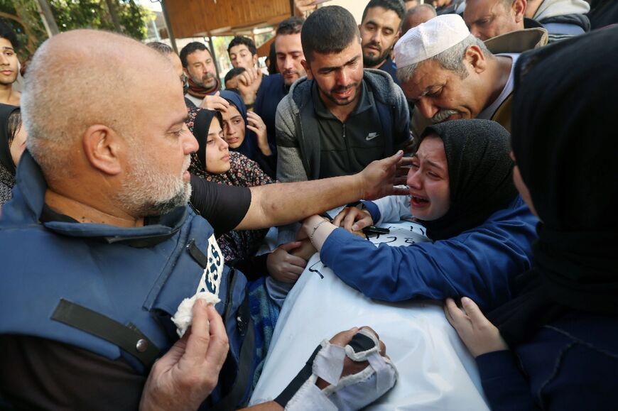 Al Jazeera's Gaza bureau chief Wael al-Dahdouh (L) comforts his daugther-in-law (R) as the mourn his son and fellow journalist Hamza