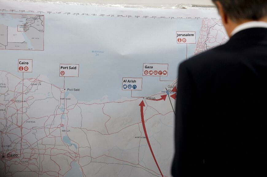 Blinken studies a map at the World Food Programme warehouse stocked with canned food for Gaza