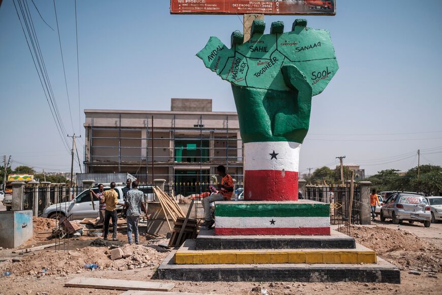 People stand next to the Independence Monument, depicting a hand holding a map of the country, in the city of Hargeisa, Somaliland, on September 19, 2021. - For 30 years, Somaliland has tried unsuccessfully to convince the world of its case for statehood, holding democratic elections and avoiding the anarchy that engulfed the rest of Somalia. (Photo by EDUARDO SOTERAS / AFP) (Photo by EDUARDO SOTERAS/AFP via Getty Images)