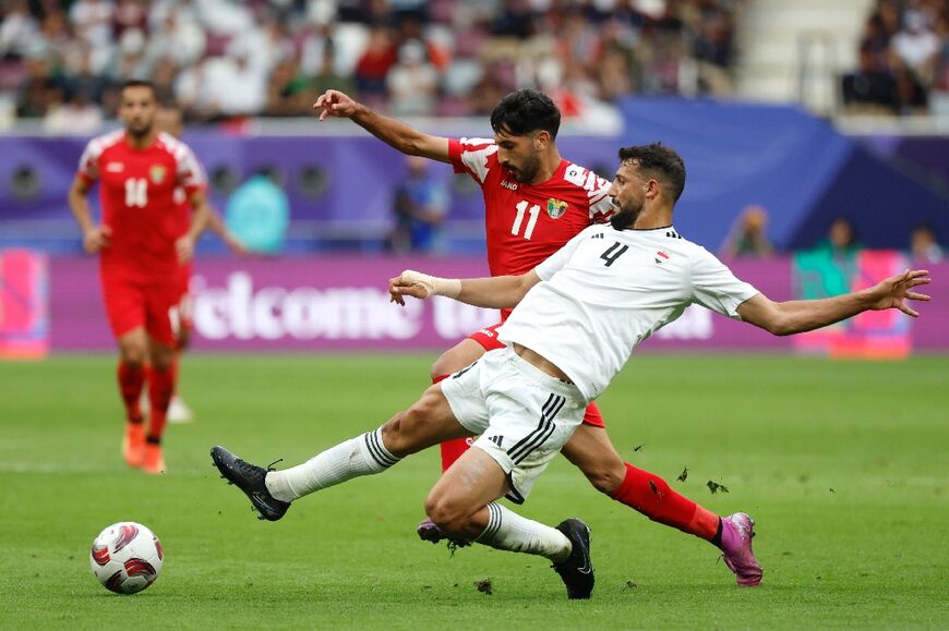 Jordan's Yazan Al-Naimat and Iraq's Saad Natiq battle for the ball