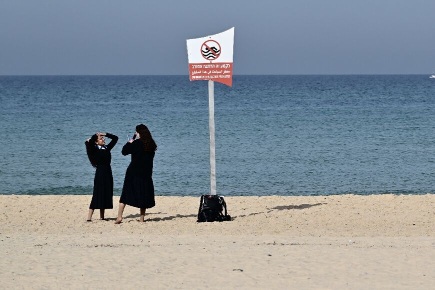 Were it not for the sound of explosions from the nearby Gaza Strip, it may have appeared as a perfectly quiet day on the sandy Ashkelon beach