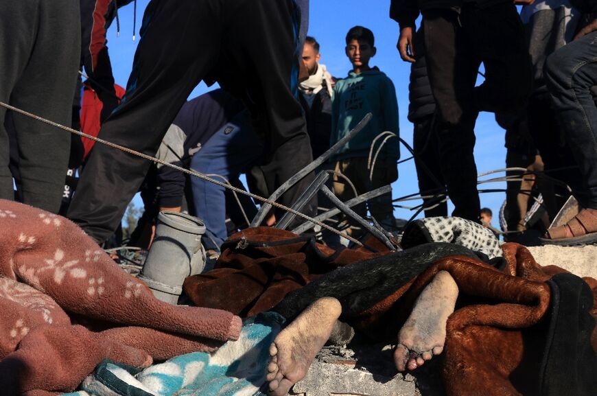 The body of a victim lies amid the rubble of a house destroyed in a strike on Rafah in the southern Gaza Strip 