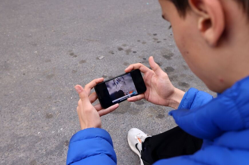 An Iranian checks the latest news on his phone in Tehran