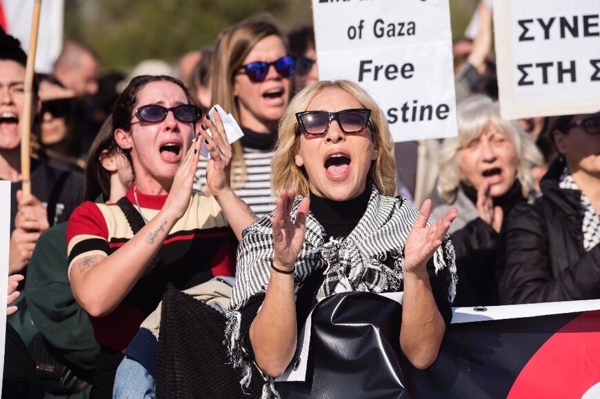 Peace protesters shout slogans in front of the gates of the Royal Air Force Akrotiri base, a British overseas territory near the Cypriot coastal city of Limassol