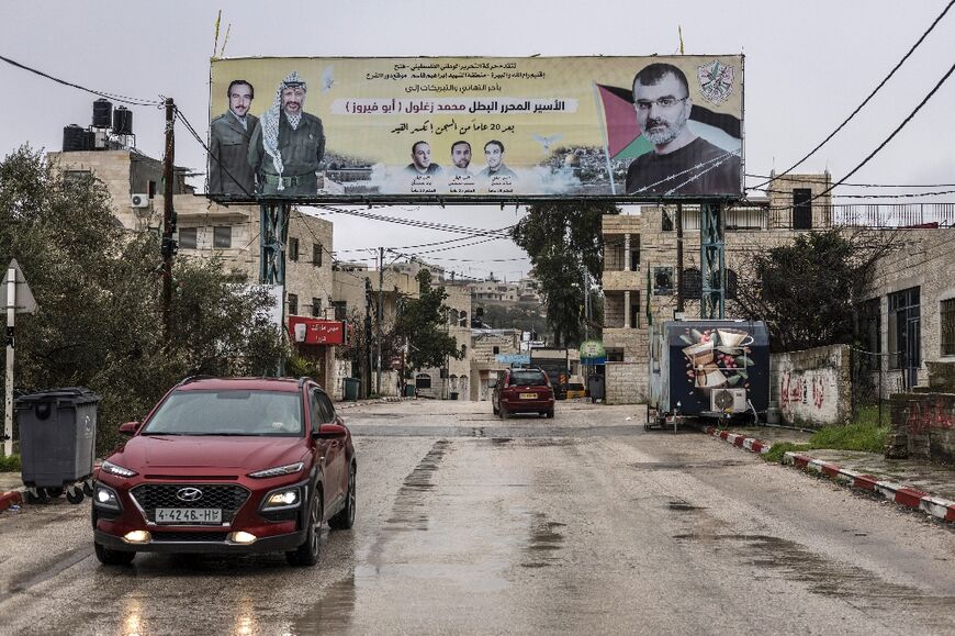 A poster depicting Palestinian prisoner Muhammad Zaghloul Hassan (R) and Palestinian leader Yasser Arafat is seen outside his family home