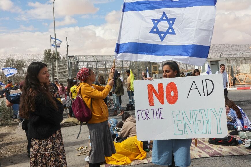 Israeli demonstrators gather by the border fence with Egypt at the Nitzana crossing in southern Israel to block humanitarian aid trucks from entering into Israel on their way to the Gaza Strip