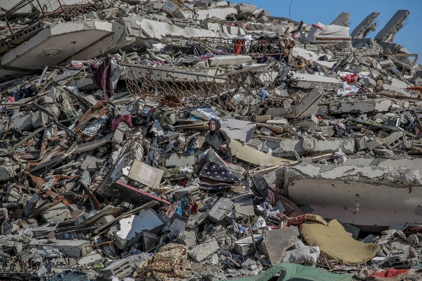 A Palestinian woman searches through the rubble after bombardment in Gaza City 