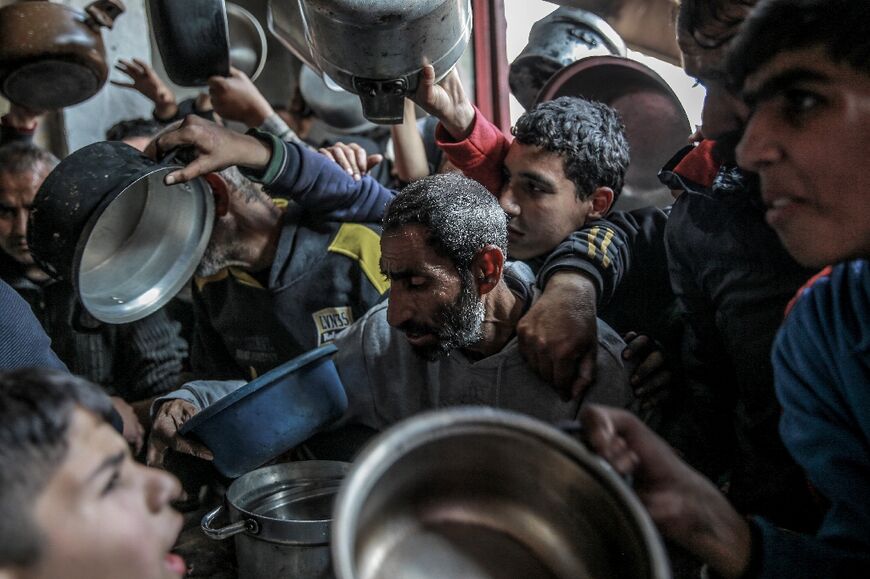 Palestinians collect aid food in Beit Lahia, in the northern Gaza Strip 