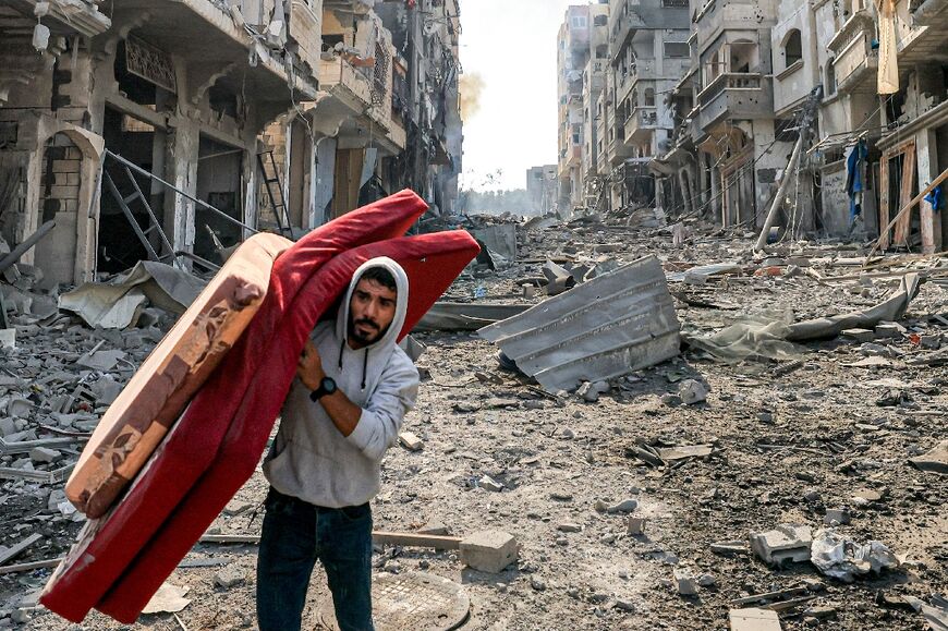 A man carries mattresses in Jabalia refugee camp