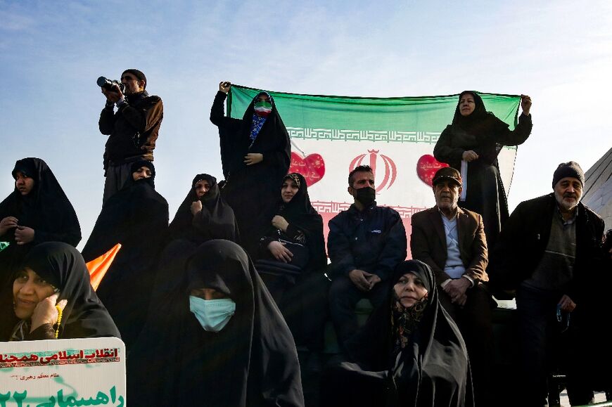 Supporters hold up the Iranian national flag as they gather to mark the 45th anniversary of the Islamic revolution in Tehran 