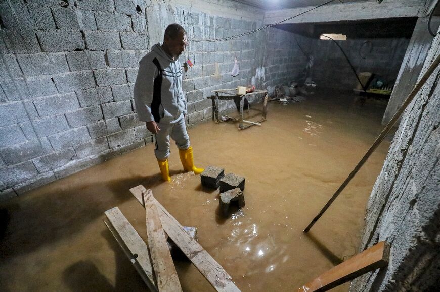 A man stands in the flooded basement of a home