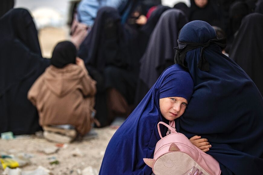 A girl hugs her mother at the al-Hol camp in Syria where the families of IS fighters are held 