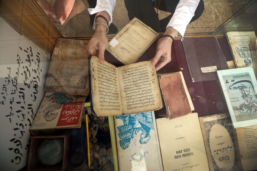 A KCAC member inspects old books before making digital copies