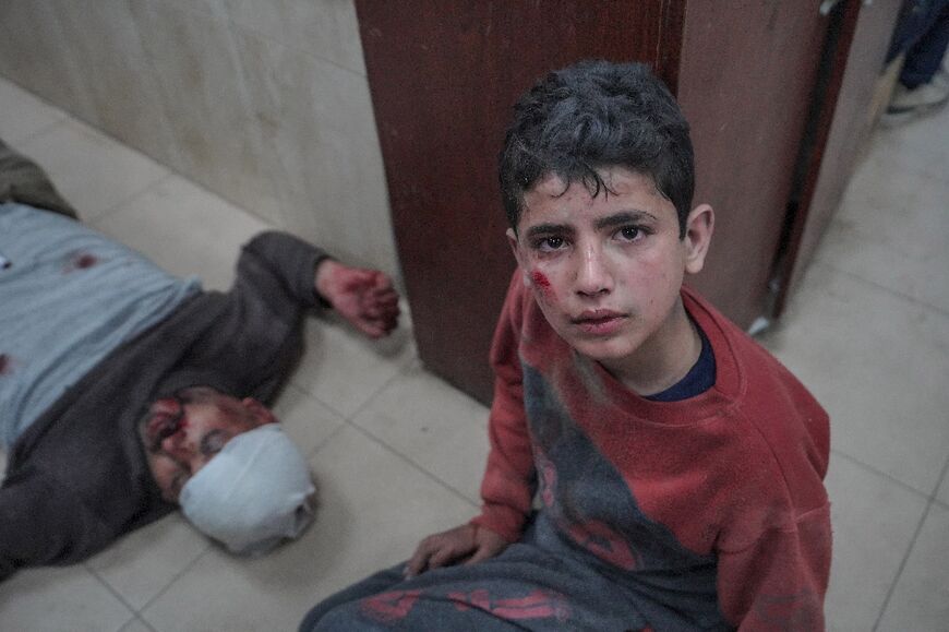 A Palestinian youth keeps an injured relative company in hospital following an Israeli strike in Gaza