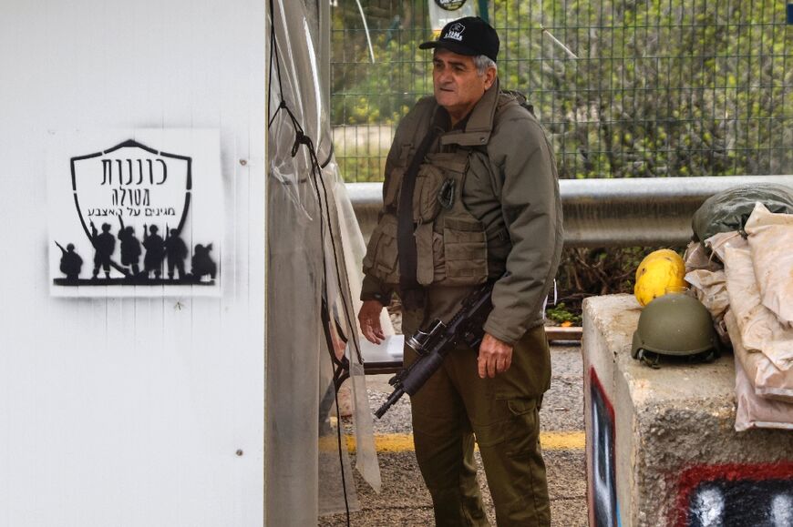 A picture taken during an organised media tour on Metula shows a man standing guard