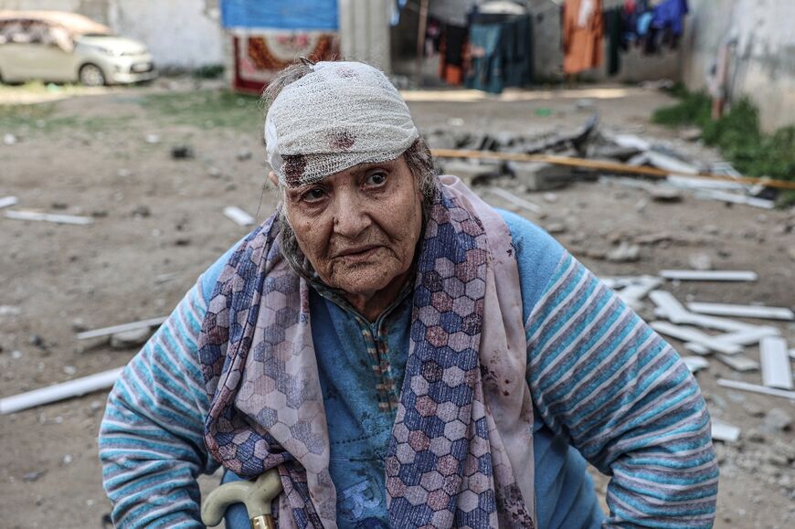 Palestinian Hoda al-Arouqi, 75, who was injured during overnight Israeli bombardment, inspects the damage to her home in Rafah in the southern Gaza Strip on March 25, 2024