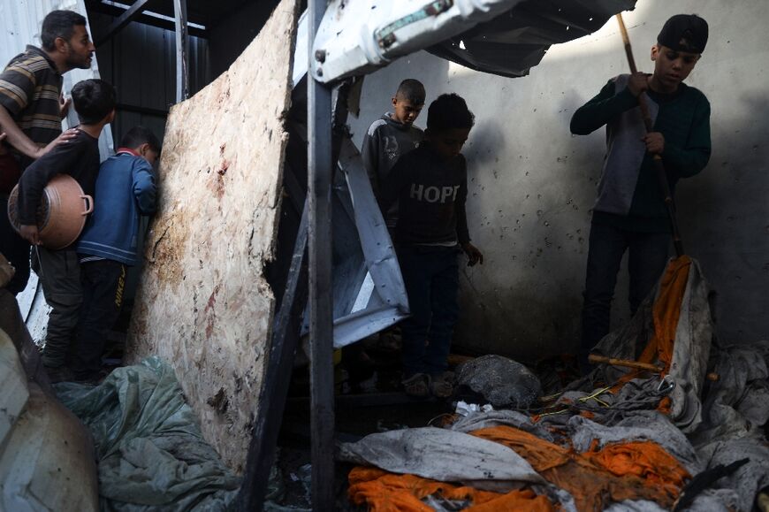 Children check the damage after an strike hit a makeshift shelter in Rafah, in Gaza's south