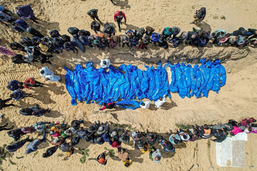 An aerial view of mourners looking on as medics prepare the 47 bodies for mass reburial