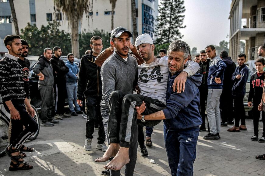 An injured man is helped outside Ahli Arab hospital in Gaza City -- the United Nations says the Gaza Strip's health system is collapsing