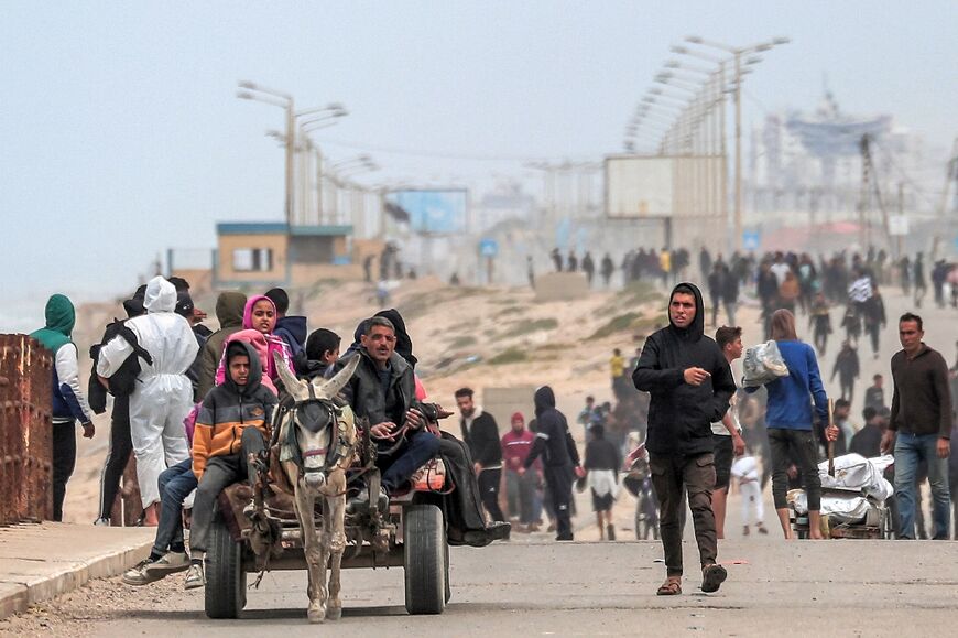 Displaced Palestinians, fleeing the area of Gaza City's al-Shifa hospital, arrive at the Nuseirat refugee camp