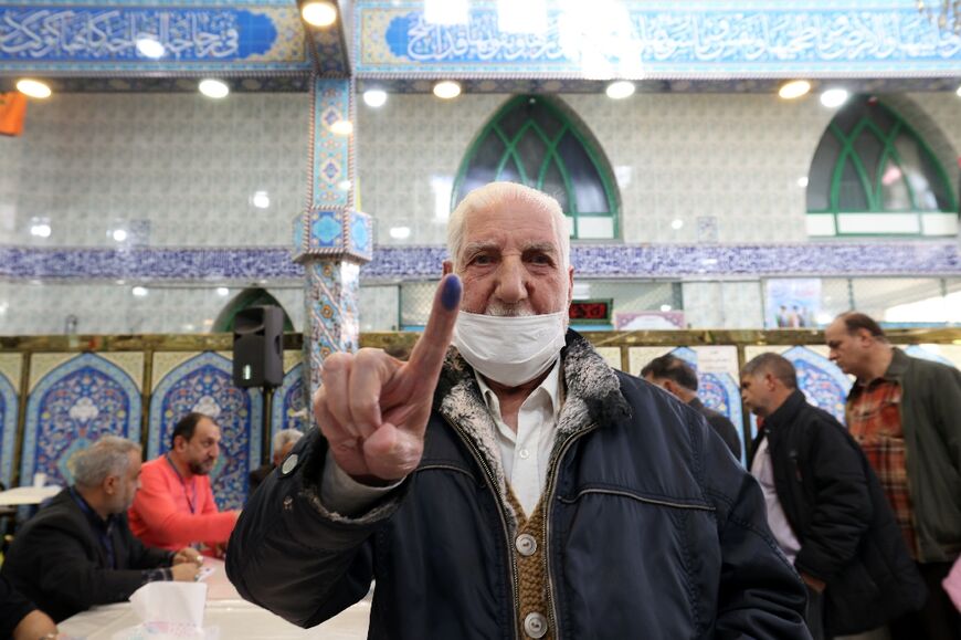 An Iranian man shows his ink-stained finger after casting his ballot -- more than 61 million people are eligible to vote in the country of 85 million 