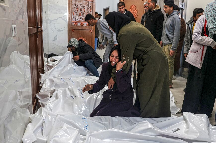 Relatives of Palestinians killed in an Israeli bombardment, mourn over their bodies at the European Hospital morgue in Khan Yunis