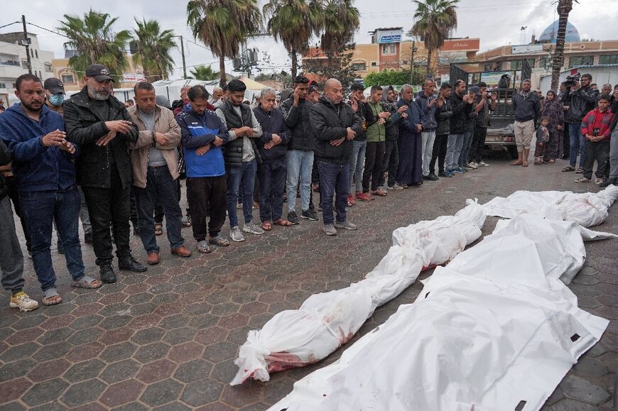 On the first day of the Eid al-Fitr holiday, Palestinians pray by the bodies of the dead from a strike on a family home in Nuseirat refugee camp in central Gaza