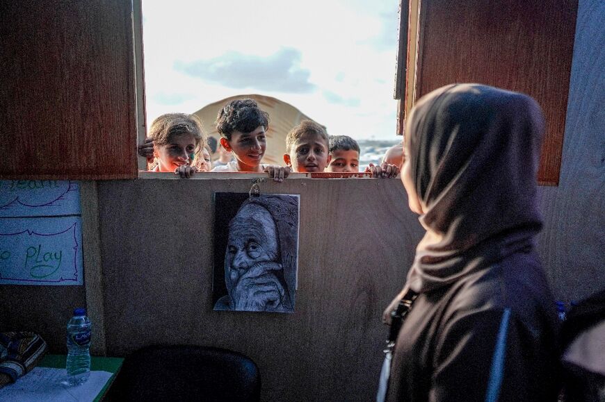 Children attend class at a makeshift school at a camp for displaced Palestinians in Deir al-Balah, central Gaza