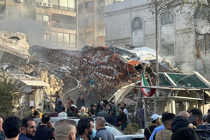 Emergency and security personnel gather at the site of strikes which hit a building adjacent to the Iranian embassy in Syria's capital Damascus, on April 1, 2024