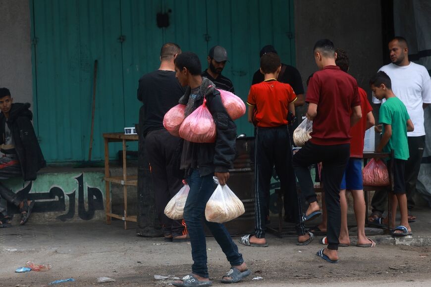 People buy bags of bread in Rafah as the UN calls for 'massive' food assistance to prevent famine