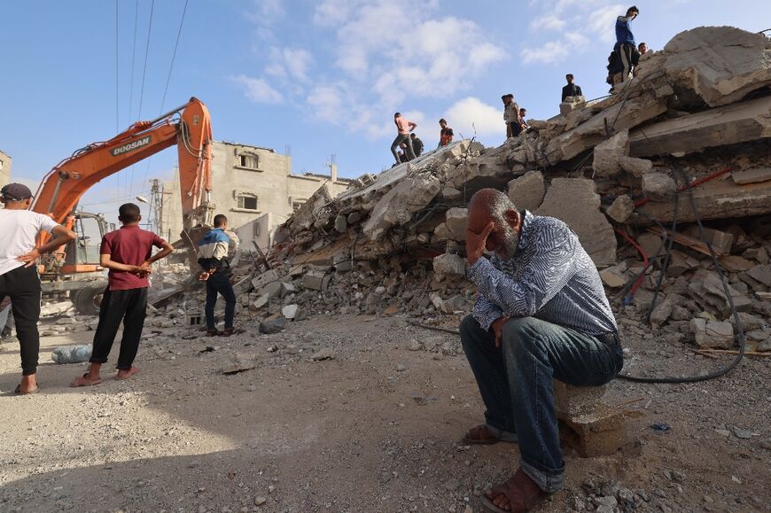 A Palestinian man waits for news of his daughter as rescue workers search for survivors after an overnight Israeli bombing in Rafah, the southern Gaza Strip