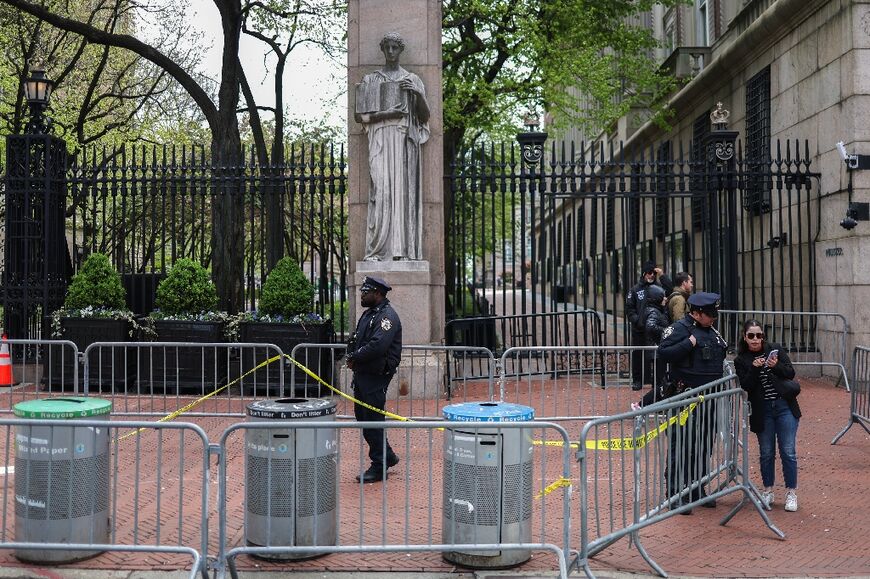 Police officers stand in front of the entrance of Columbia University 